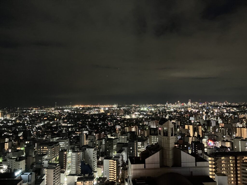 手前に川崎の街並み、奥にインターコンチネンタルなどみなとみらいの街並み(夜景)